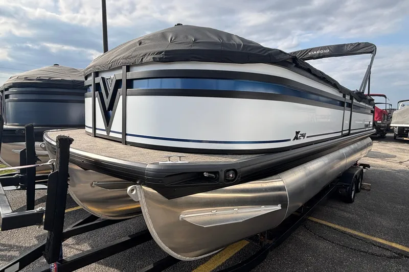 Slide: The Image of 2026 Viaggio Lago X24U pontoon boat with cover, parked on a trailer. - 6