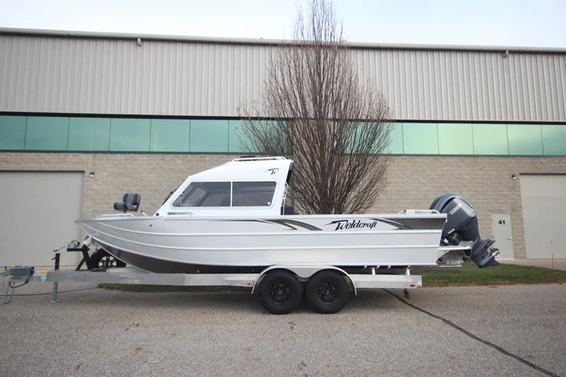 Slide: The Image of 2025 Weldcraft 240 Maverick DV boat on trailer, parked outside industrial building. - 3