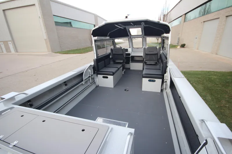 Slide: The Image of 2025 Weldcraft 240 Maverick DV boat interior with seating, parked outdoors. - 9
