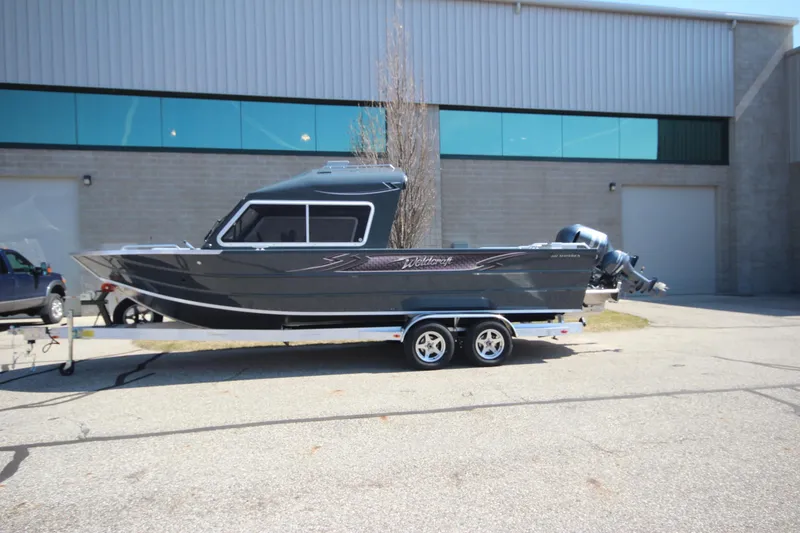 The Image of 2026 Weldcraft 240 Maverick DV boat on trailer, parked outside industrial building. - 0