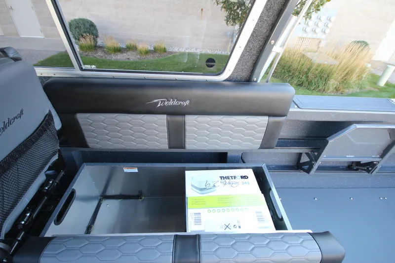 Slide: The Image of Interior of 2027 Weldcraft 240 Maverick DV boat with storage compartment open. - 25