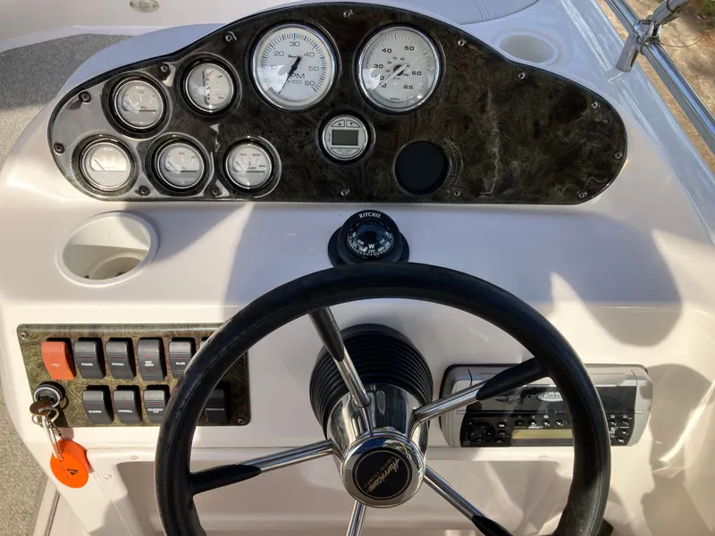 Slide: The Image of Dashboard of a 2004 Hurricane 201 GS boat with steering wheel and gauges. - 14