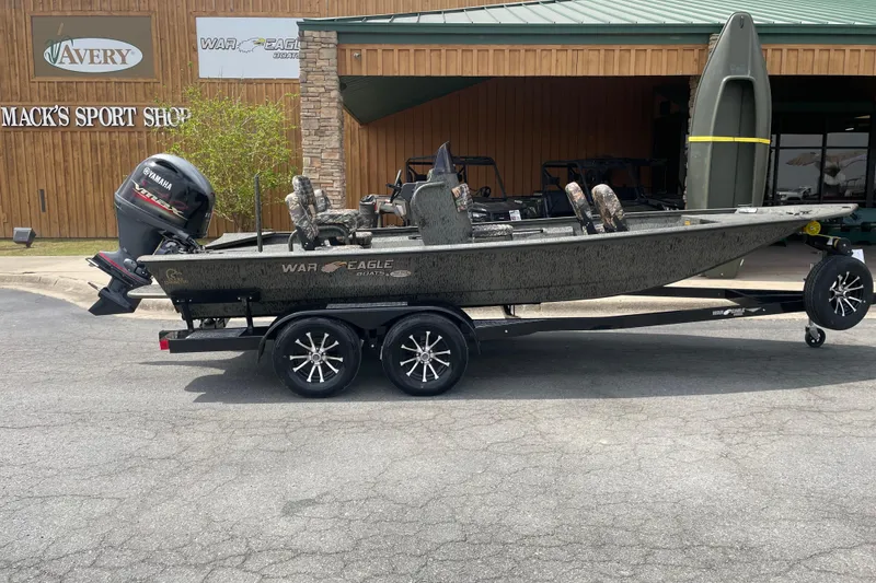 Slide: The Image of 2026 War Eagle 961 Blackhawk boat on trailer outside Mack's Sport Shop. - 1