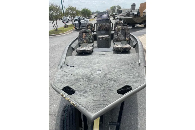 Slide: The Image of 2026 War Eagle 961 Blackhawk boat with camouflage seats, parked outdoors. - 10