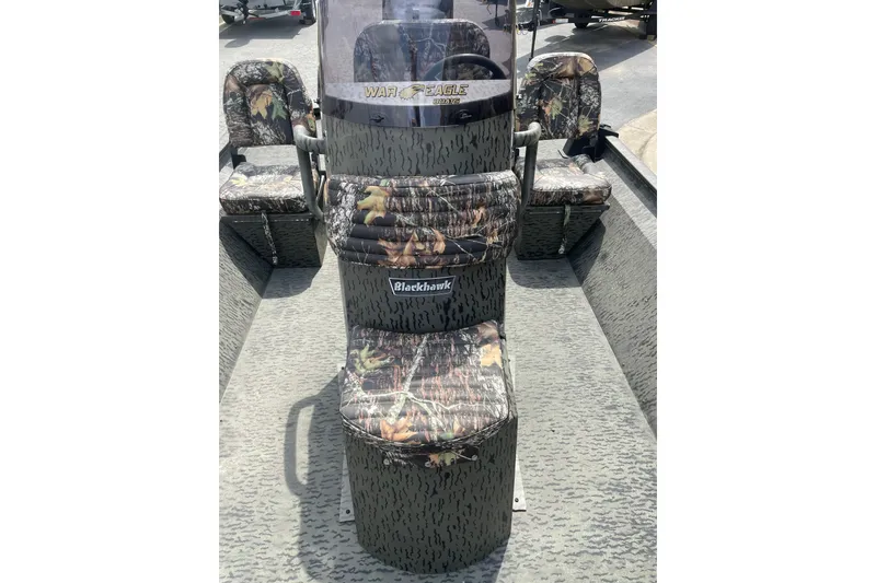 Slide: The Image of 2026 War Eagle 961 Blackhawk boat interior with camouflage seating and console. - 12