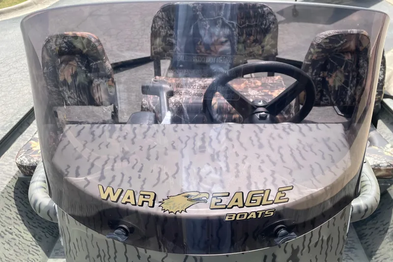 Slide: The Image of 2026 War Eagle 961 Blackhawk boat dashboard with camouflage seats and steering wheel. - 13