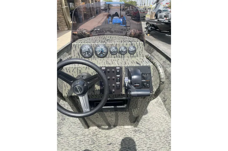 Slide: The Image of 2026 War Eagle 961 Blackhawk boat dashboard with steering wheel and control panel. - 15