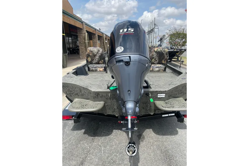 Slide: The Image of 2026 War Eagle 961 Blackhawk boat with powerful outboard motor, parked outdoors. - 8