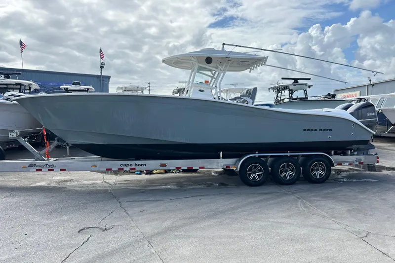 Slide: The Image of 2015 Cape Horn 32 XS boat on trailer, parked outdoors under cloudy sky. - 1