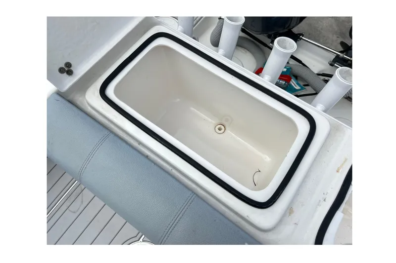 Slide: The Image of Open storage compartment on 2015 Cape Horn 32 XS boat, featuring rod holders and clean interior. - 6