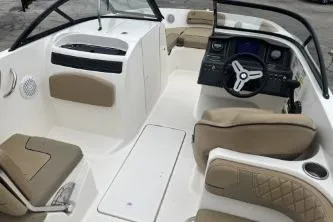 Slide: The Image of 2022 Bayliner VR6 Bowrider OB interior with beige seating and modern dashboard. - 8