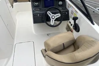 Slide: The Image of 2022 Bayliner VR6 Bowrider OB cockpit with steering wheel and beige seating. - 9