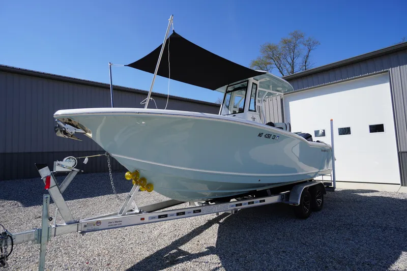 Slide: The Image of 2024 Tidewater 232 LXF boat on trailer, parked outdoors under a clear blue sky. - 1