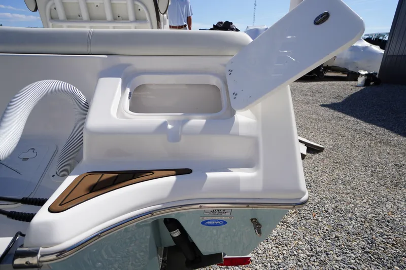 Slide: The Image of 2024 Tidewater 232 LXF boat with open storage compartment and hose on deck. - 11