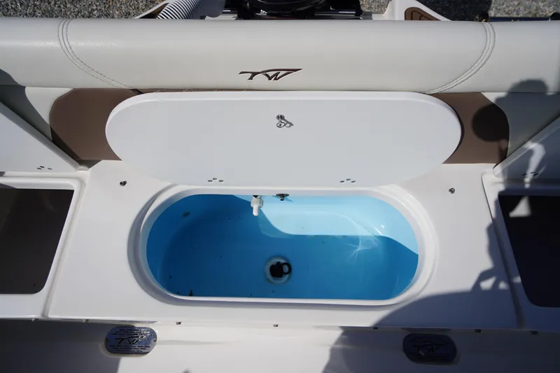 Slide: The Image of 2024 Tidewater 232 LXF boat livewell with open lid, showcasing interior design. - 20