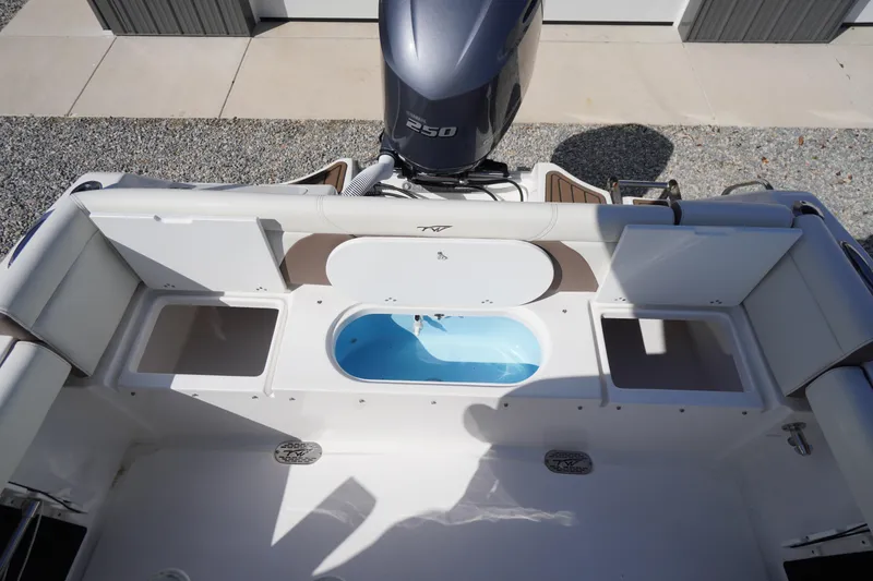 Slide: The Image of 2024 Tidewater 232 LXF boat interior with motor and storage compartments. - 23