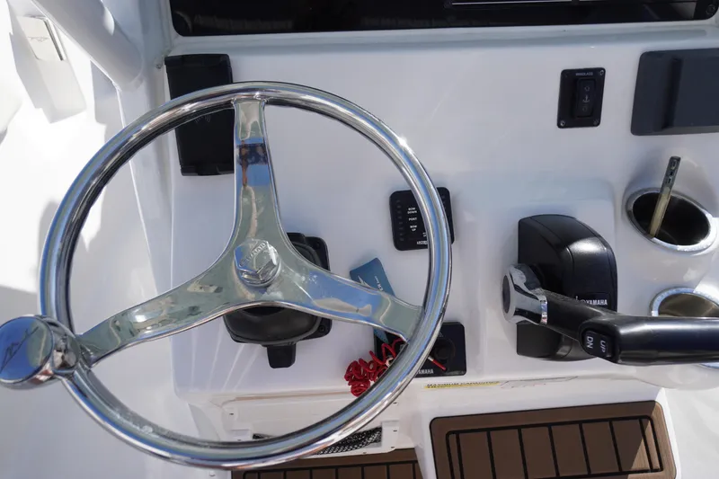 Slide: The Image of 2024 Tidewater 232 LXF boat steering wheel and control panel close-up. - 29