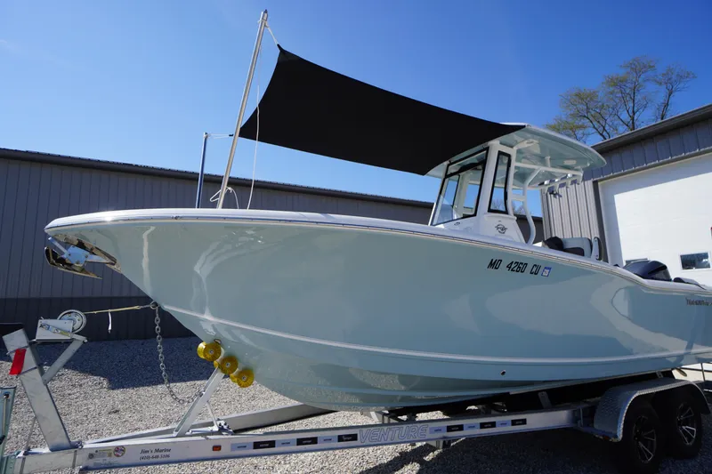 Slide: The Image of 2024 Tidewater 232 LXF boat on trailer with sunshade, parked outdoors. - 3