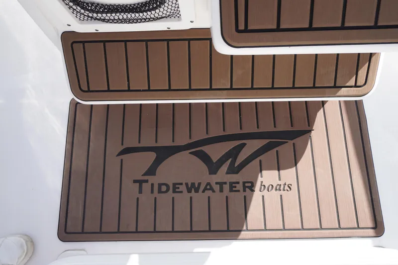 Slide: The Image of Tidewater 232 LXF 2024 boat deck with logo and wood-style flooring. - 30