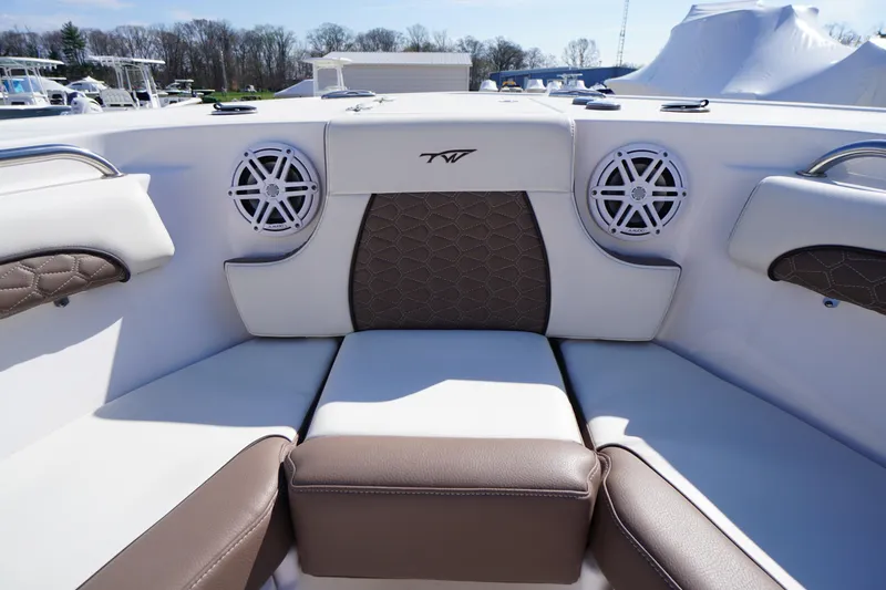 Slide: The Image of 2024 Tidewater 232 LXF boat interior with cushioned seating and built-in speakers. - 37