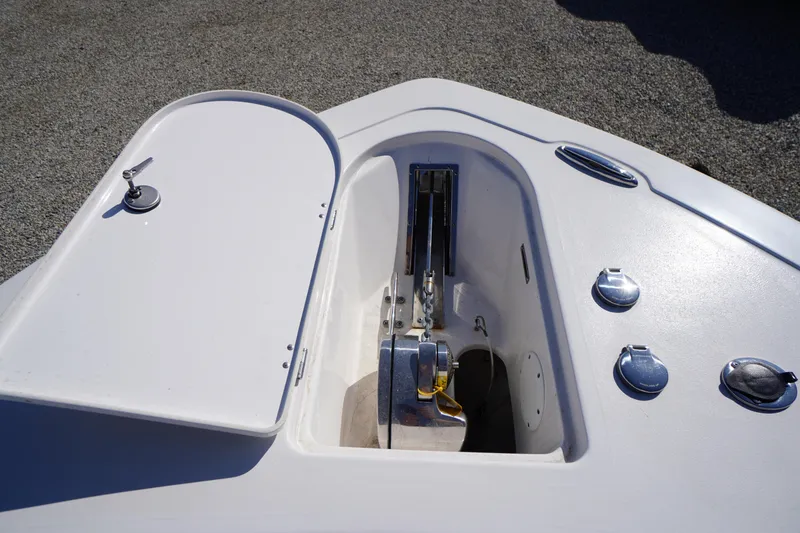 Slide: The Image of 2024 Tidewater 232 LXF boat anchor compartment with open hatch and hardware. - 39