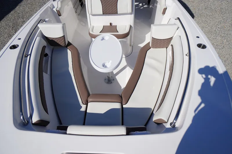 Slide: The Image of 2024 Tidewater 232 LXF boat interior with white and brown seating and a central table. - 46
