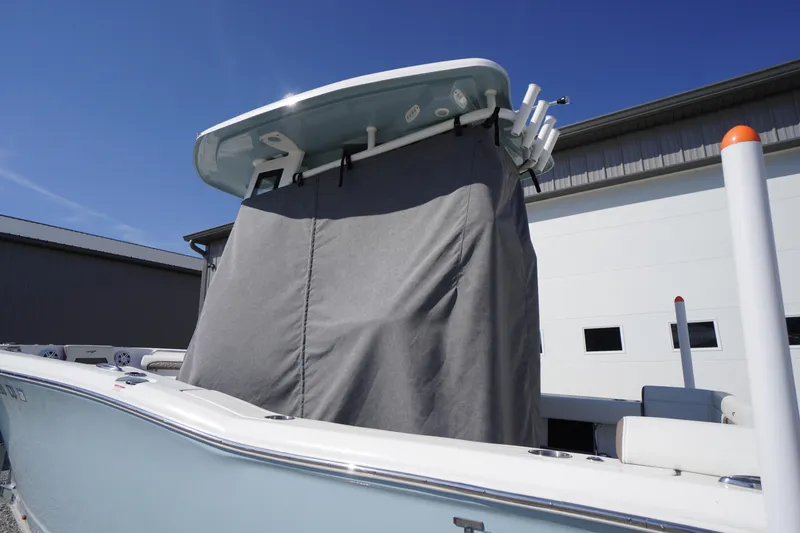 Slide: The Image of 2024 Tidewater 232 LXF boat with covered console, docked near a building. - 5
