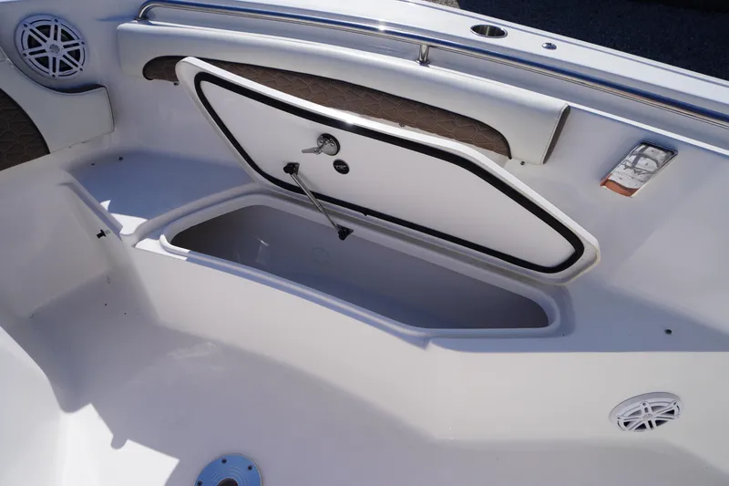 Slide: The Image of 2024 Tidewater 232 LXF boat interior storage compartment with open hatch and speakers. - 54