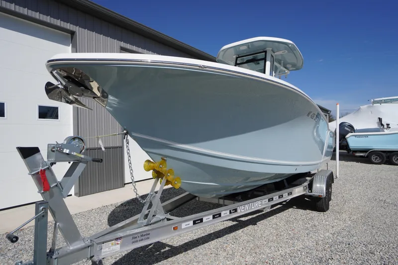 Slide: The Image of 2024 Tidewater 232 LXF boat on trailer, parked outdoors near a building. - 6