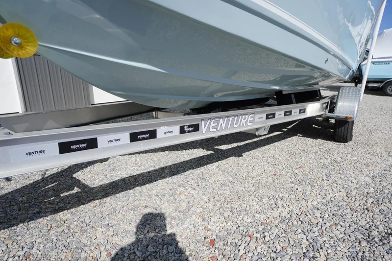 Slide: The Image of 2024 Tidewater 232 LXF boat on Venture trailer, parked on gravel surface. - 7