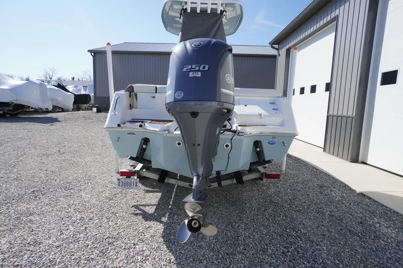 Slide: The Image of 2024 Tidewater 232 LXF boat with Yamaha 250 engine, parked on gravel near a garage. - 8