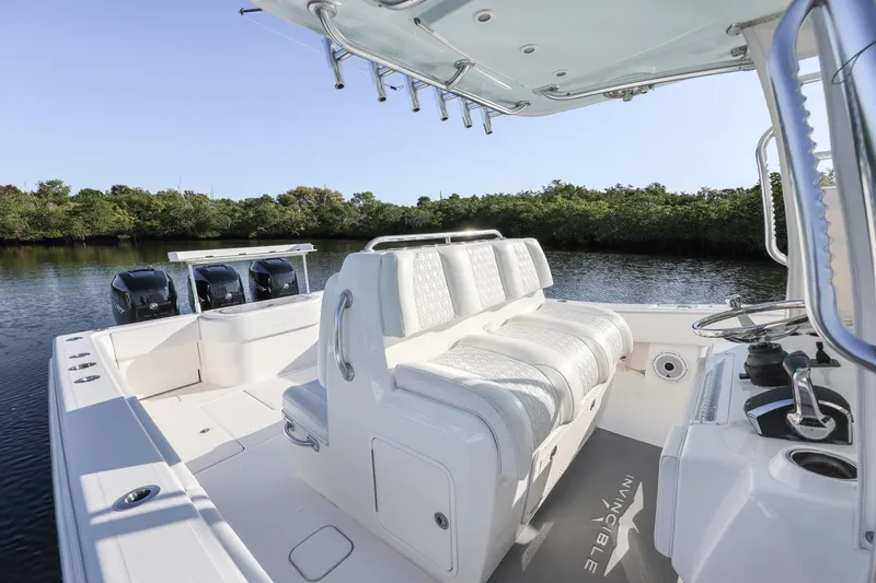 Slide: The Image of 2016 Invincible 39 Open Fisherman boat with triple engines on a calm waterway. - 19