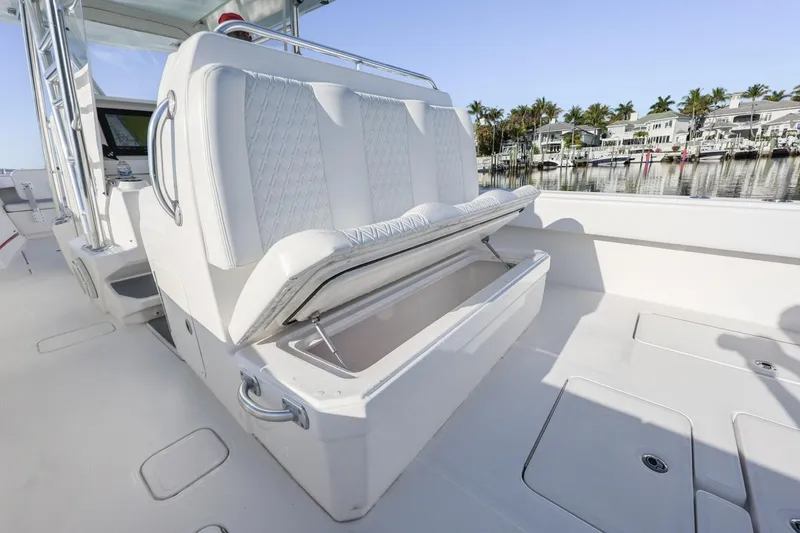 Slide: The Image of 2016 Invincible 39 Open Fisherman boat with open storage compartment, docked near waterfront homes. - 26