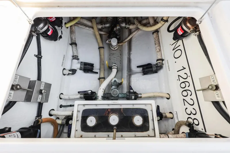 Slide: The Image of Engine compartment of 2016 Invincible 39 Open Fisherman, showcasing pipes and control switches. - 28