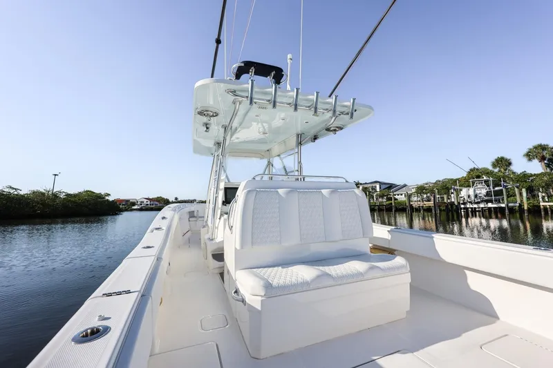 Slide: The Image of 2016 Invincible 39 Open Fisherman boat on calm water, featuring sleek white seating. - 29