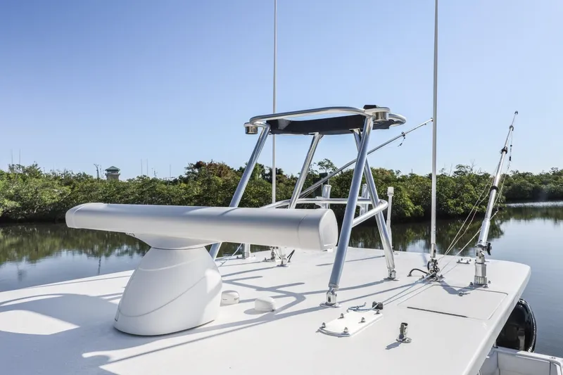 Slide: The Image of 2016 Invincible 39 Open Fisherman boat with fishing rods and tower, set against a serene water backdrop. - 32