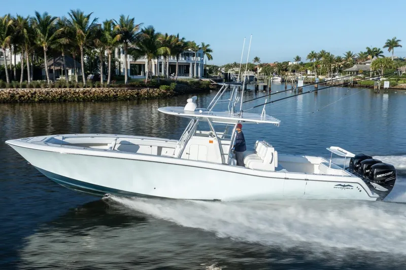 Slide: The Image of 2016 Invincible 39 Open Fisherman boat cruising on a scenic waterway with palm trees. - 34