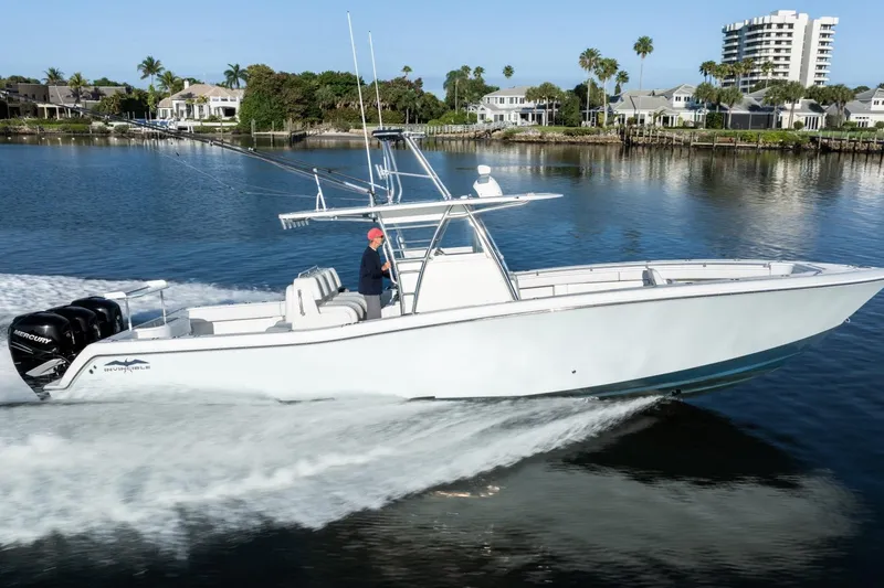 Slide: The Image of 2016 Invincible 39 Open Fisherman boat cruising on calm waters near waterfront homes. - 7
