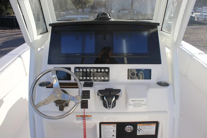 Slide: The Image of 2026 Sea Fox 288 Commander boat dashboard with steering wheel and control panel. - 22