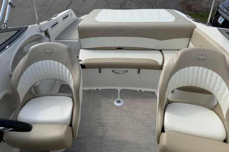 Slide: The Image of 2016 Stingray 215 LR boat interior with beige and white seating. - 11