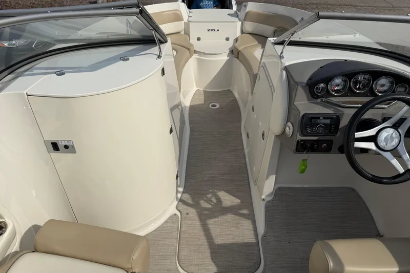 Slide: The Image of 2016 Stingray 215 LR boat interior with steering wheel and seating area. - 12