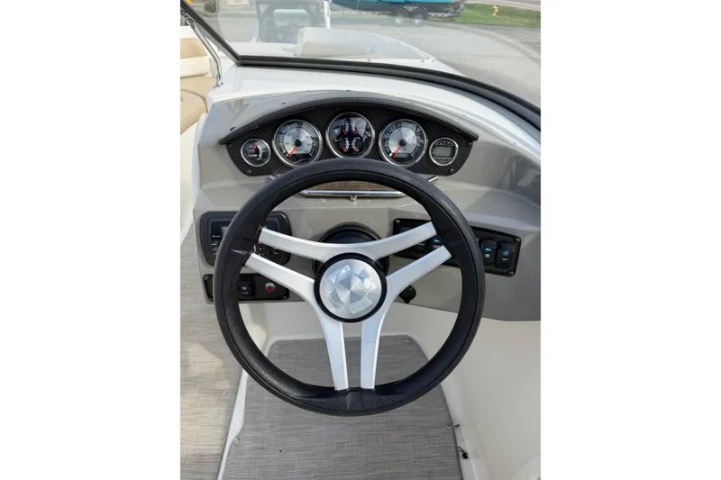 Slide: The Image of Steering wheel and dashboard of 2016 Stingray 215 LR boat, featuring gauges and controls. - 13