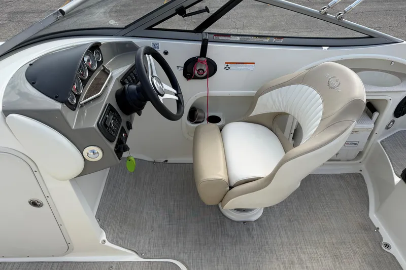 Slide: The Image of Interior of a 2016 Stingray 215 LR boat, featuring a sleek steering wheel and comfortable seating. - 17