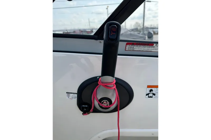 Slide: The Image of Throttle control of a 2016 Stingray 215 LR boat with a pink cord wrapped around it. - 21