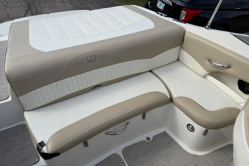 Slide: The Image of 2016 Stingray 215 LR boat interior with beige and white seating, featuring sleek design and comfort. - 5