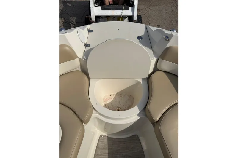 Slide: The Image of 2016 Stingray 215 LR boat interior with beige seating and storage compartment. - 8