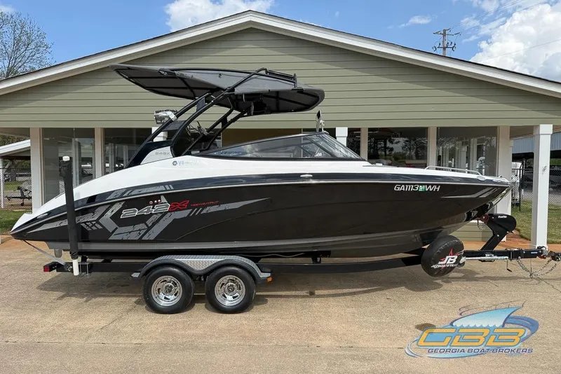 Slide: The Image of 2017 Yamaha Boats 242X E-Series on trailer, parked outside a building. - 1