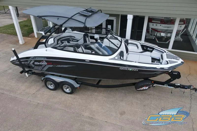Slide: The Image of 2017 Yamaha Boats 242X E-Series on trailer, sleek design, black and white exterior. - 16