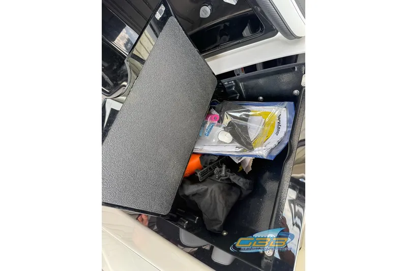 Slide: The Image of Storage compartment of a 2017 Yamaha Boats 242X E-Series with various items inside. - 34