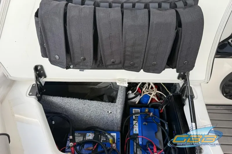 Slide: The Image of Open storage compartment of 2017 Yamaha Boats 242X E-Series, showing battery and wiring. - 35
